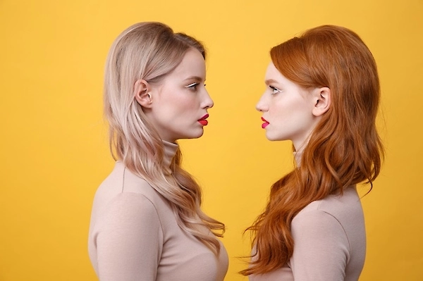 Zwei Frauen stehen sich gegenüber und zeigen sinnbildlich, wie Gesichter durch Deepfake-KI verändert oder ausgetauscht werden können.